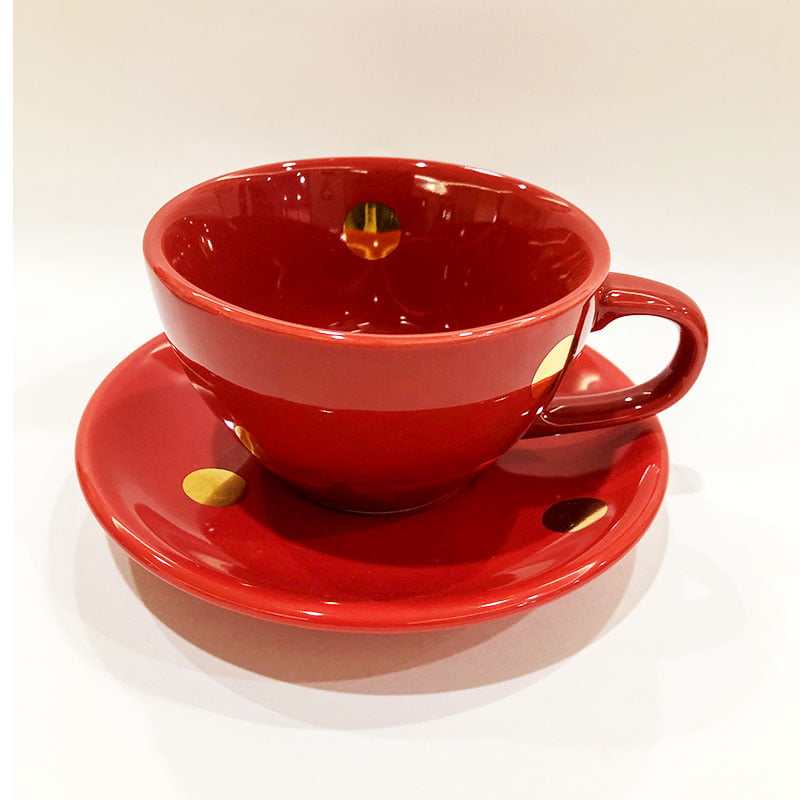 Xícara de chá vermelha com bolas douradas